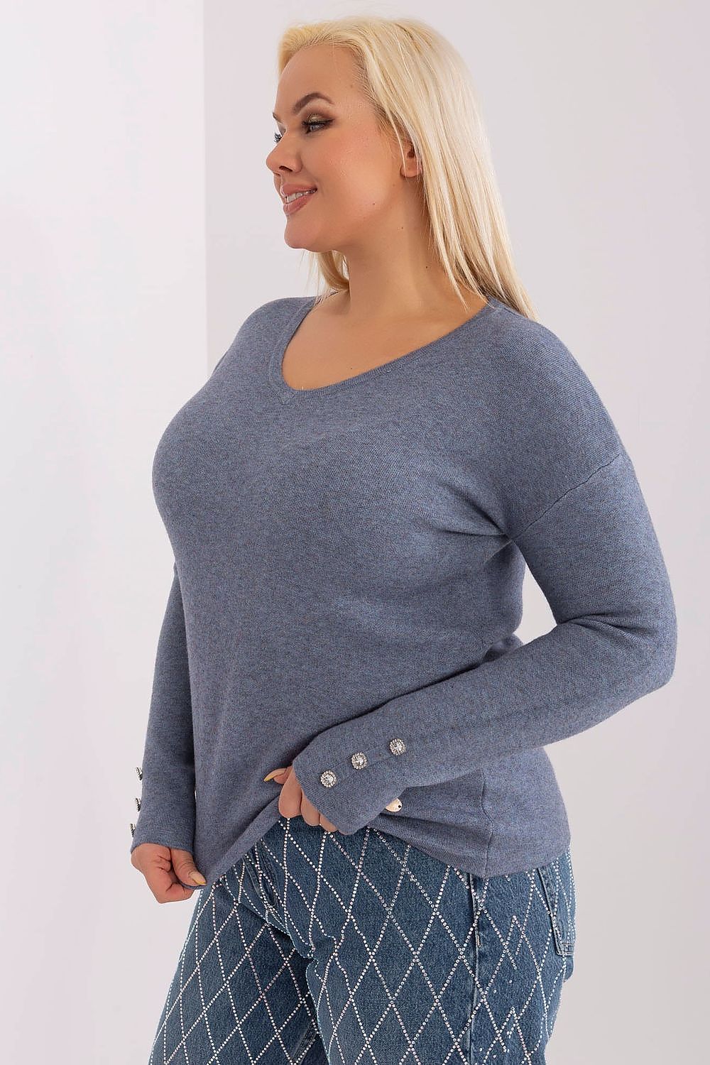 Detailed shot of blue viscose sweater fabric and button cuff design.