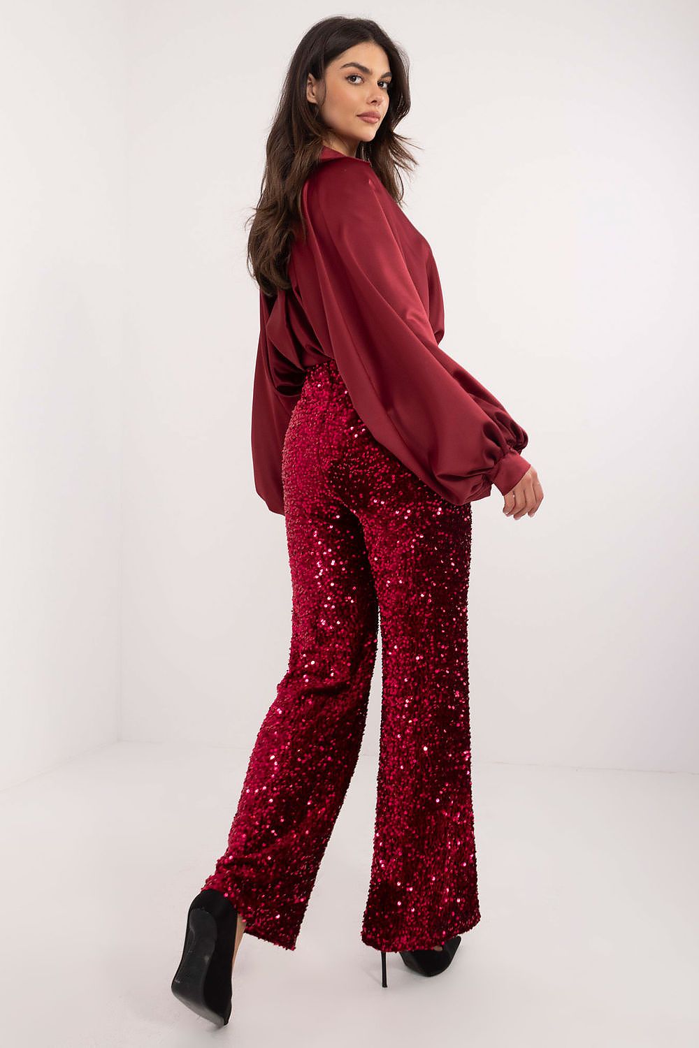 Red sequin trousers side view showing sparkle and flattering fit.