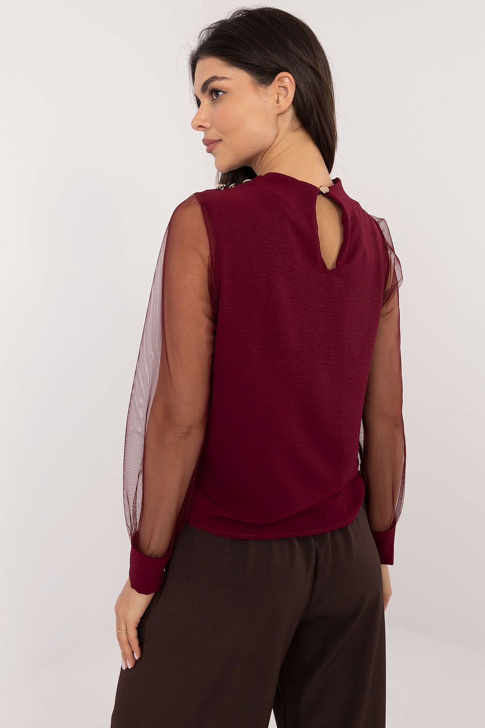 Close-up of red blouse shoulder detail — pleated design with puffy mesh sleeve and buttons.