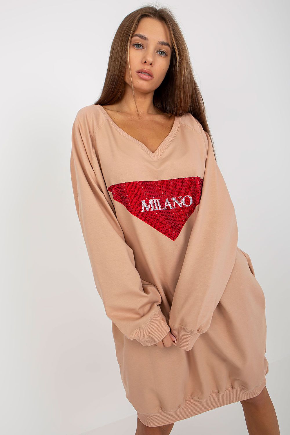Woman wearing a beige dress with a red heart-shaped logo on a white background