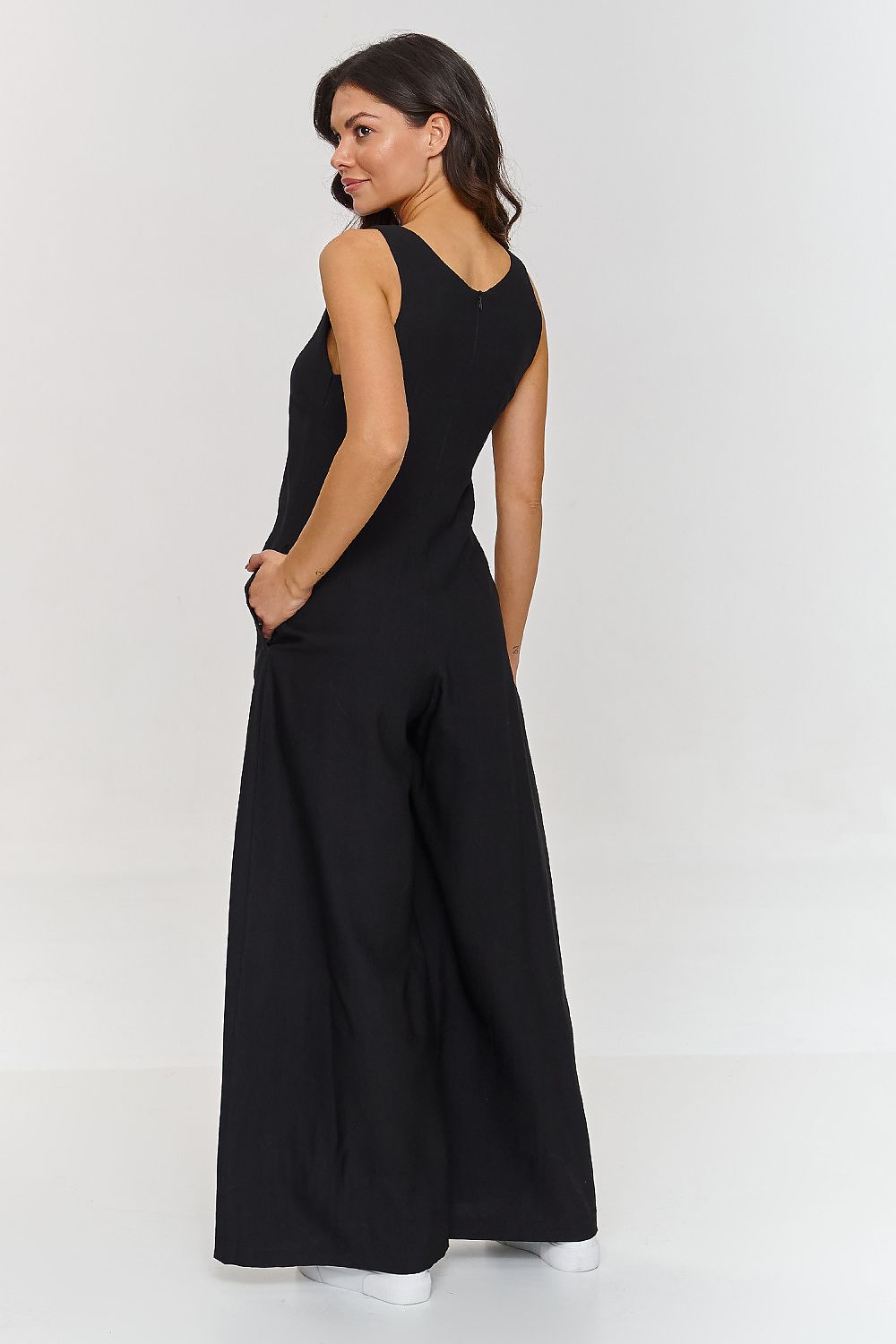 Woman wearing a black sleeveless jumpsuit on a white background