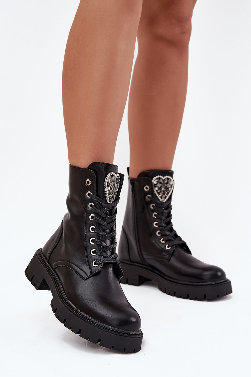 Side profile of black ankle boots showing flat heel and platform sole for comfort.