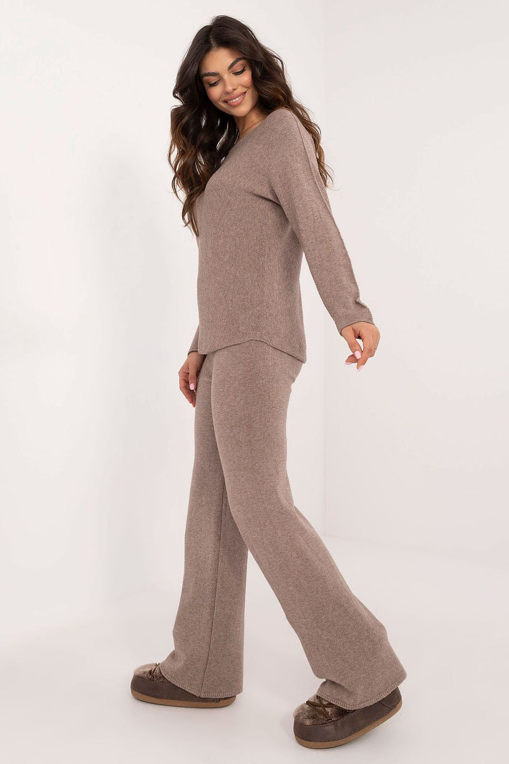 Two-piece women’s outfit featuring a sweater with long sleeves and high-waist pants – side view.