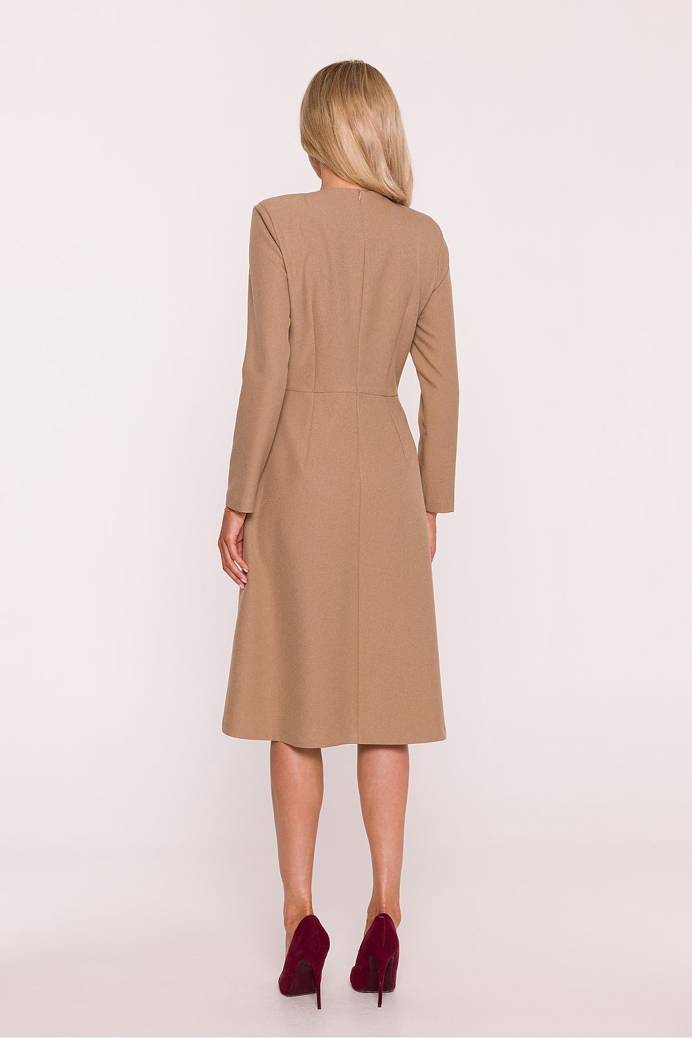 Woman wearing a beige coat against a white background