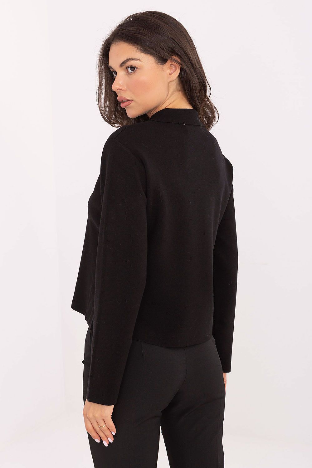 Model wearing black elegant sweater styled with formal trousers.