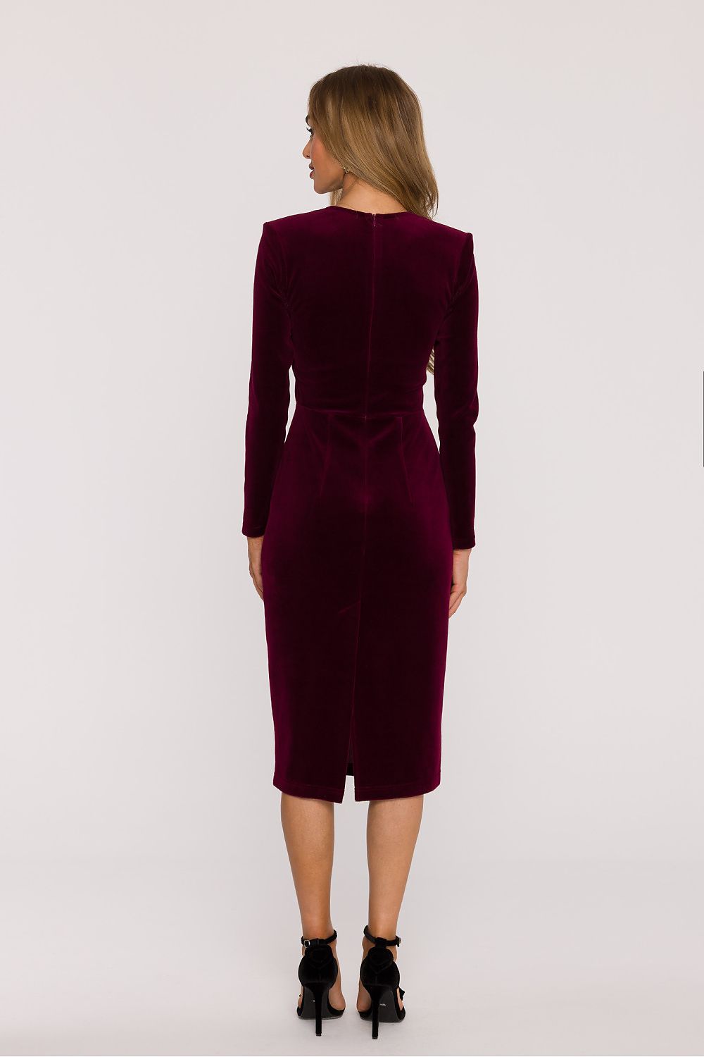 Woman wearing a burgundy velvet dress on a white background