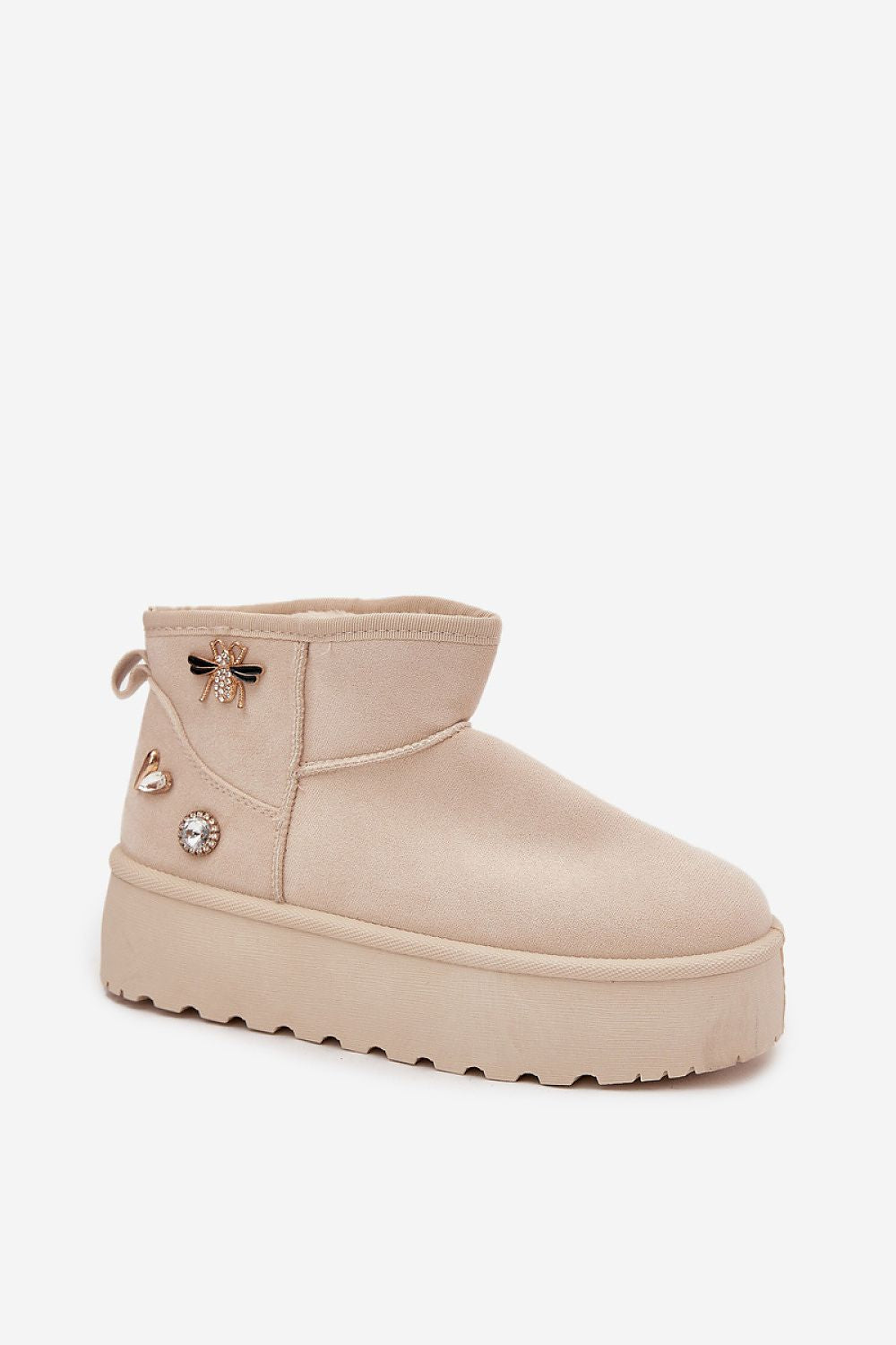 Close-up of beige faux suede winter boots highlighting cozy fur lining and textured sole.