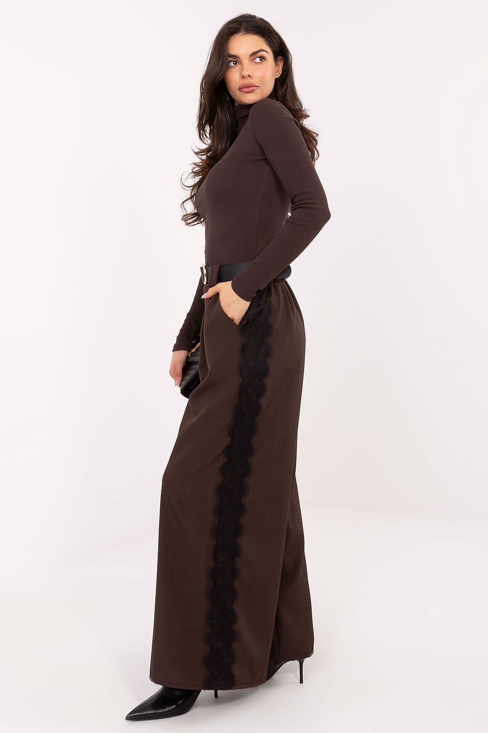 View of fitted turtleneck sweater styled with trousers for a chic everyday look.