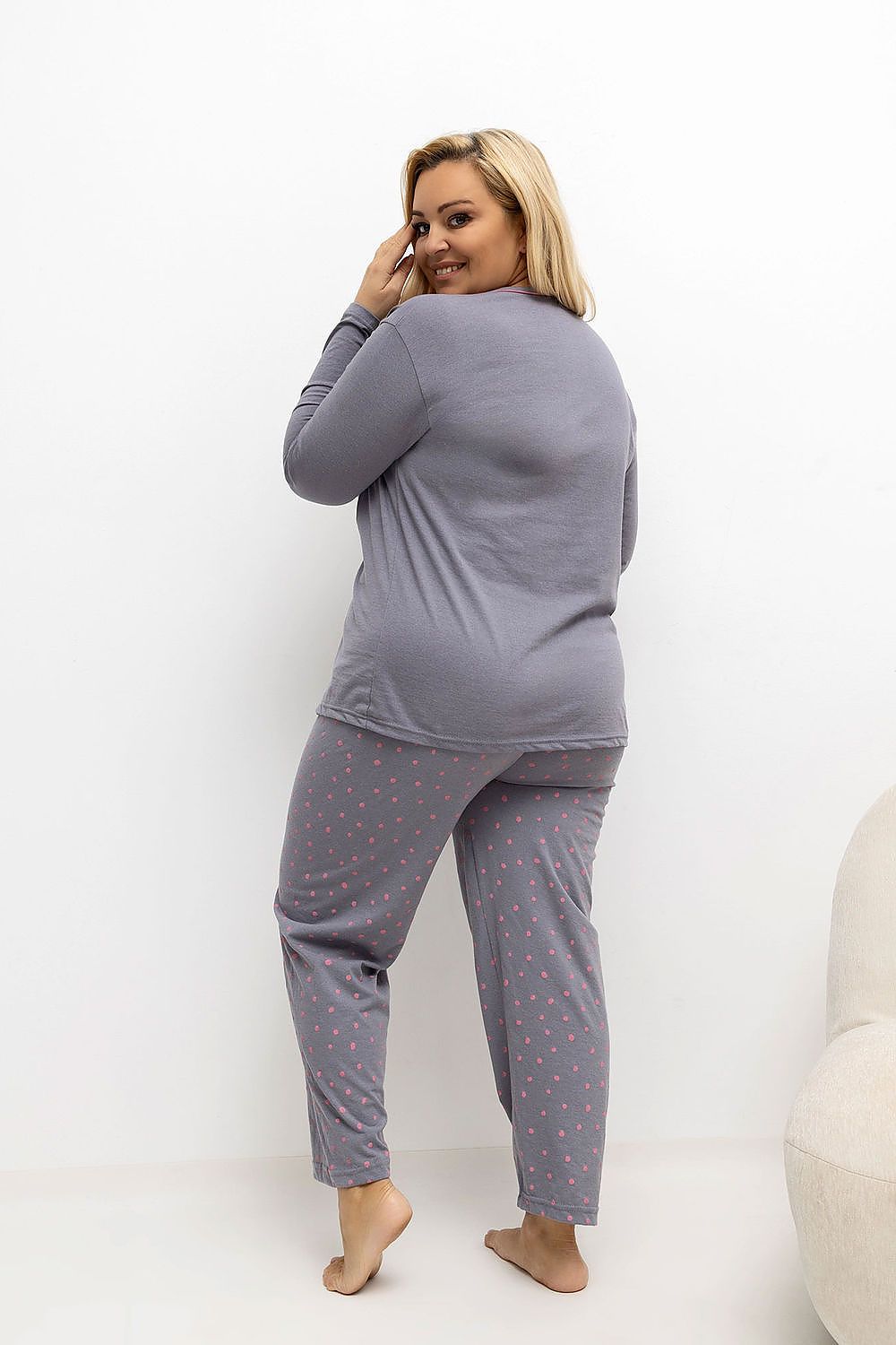 Woman wearing a gray pajama set with a white background