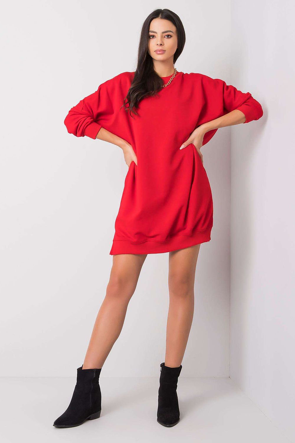 Woman wearing a red dress with black boots on a white background