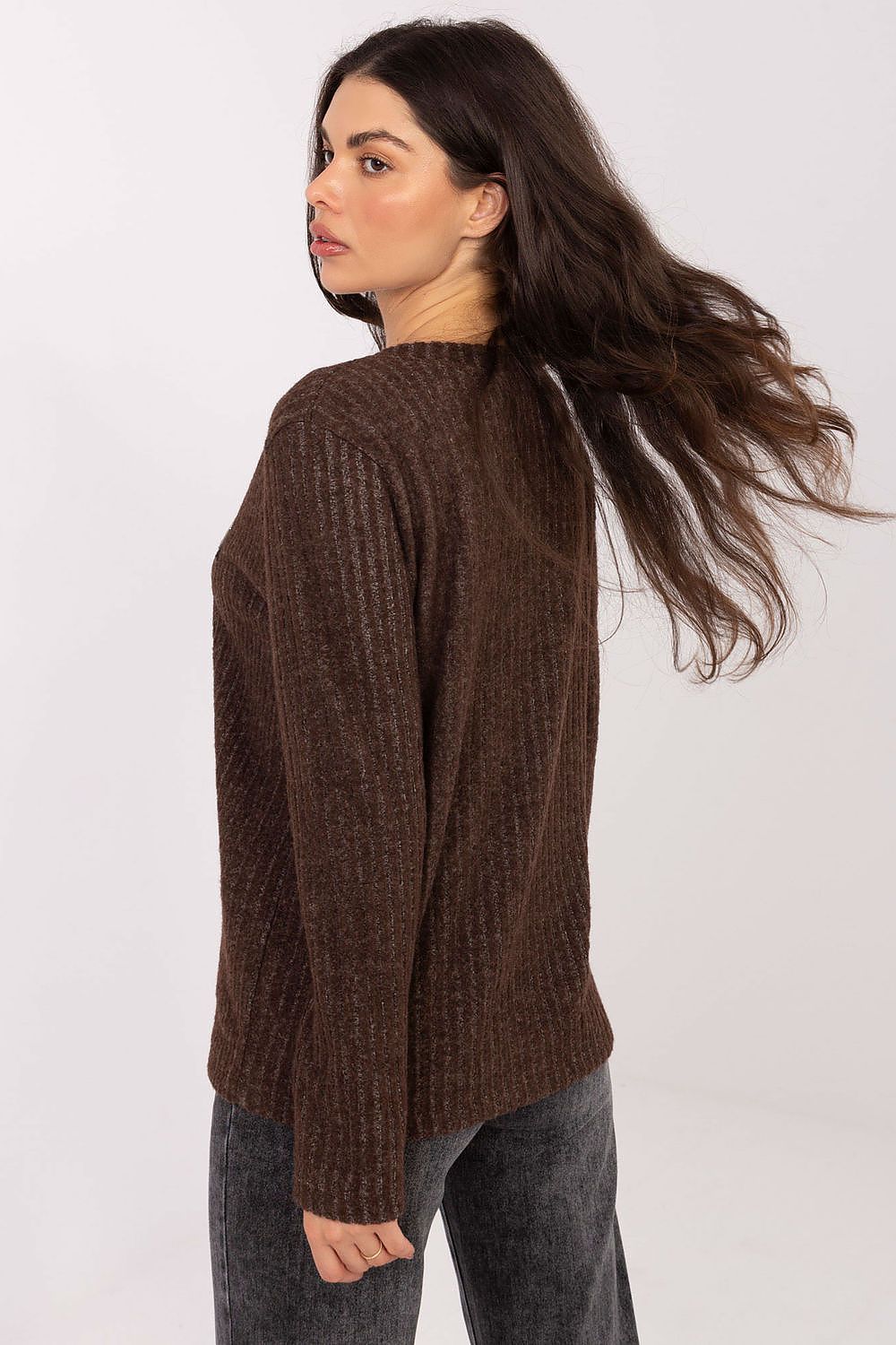 Woman wearing a brown sweater against a white background