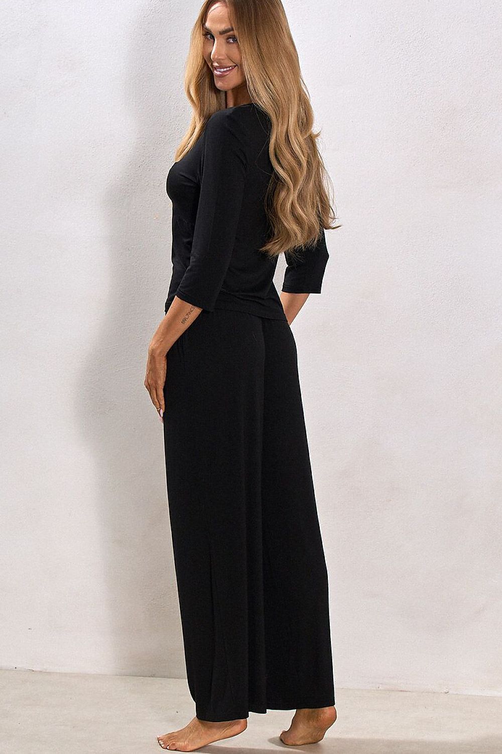 Woman wearing a black outfit against a white background