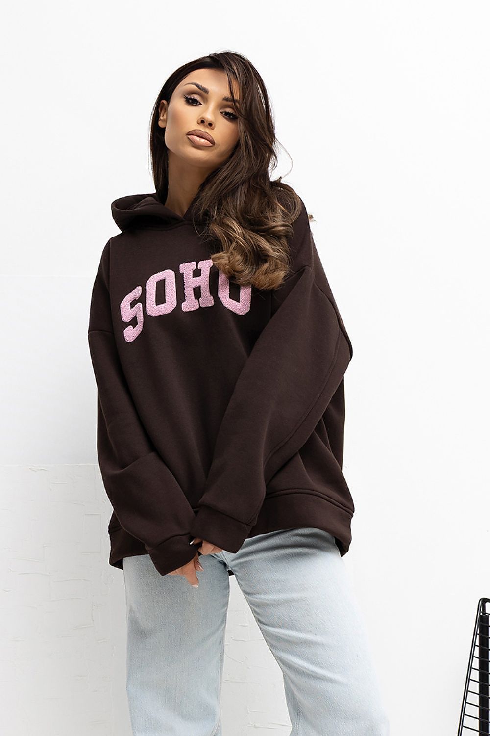 Person wearing a brown hoodie with 'SOHO' text on a white background