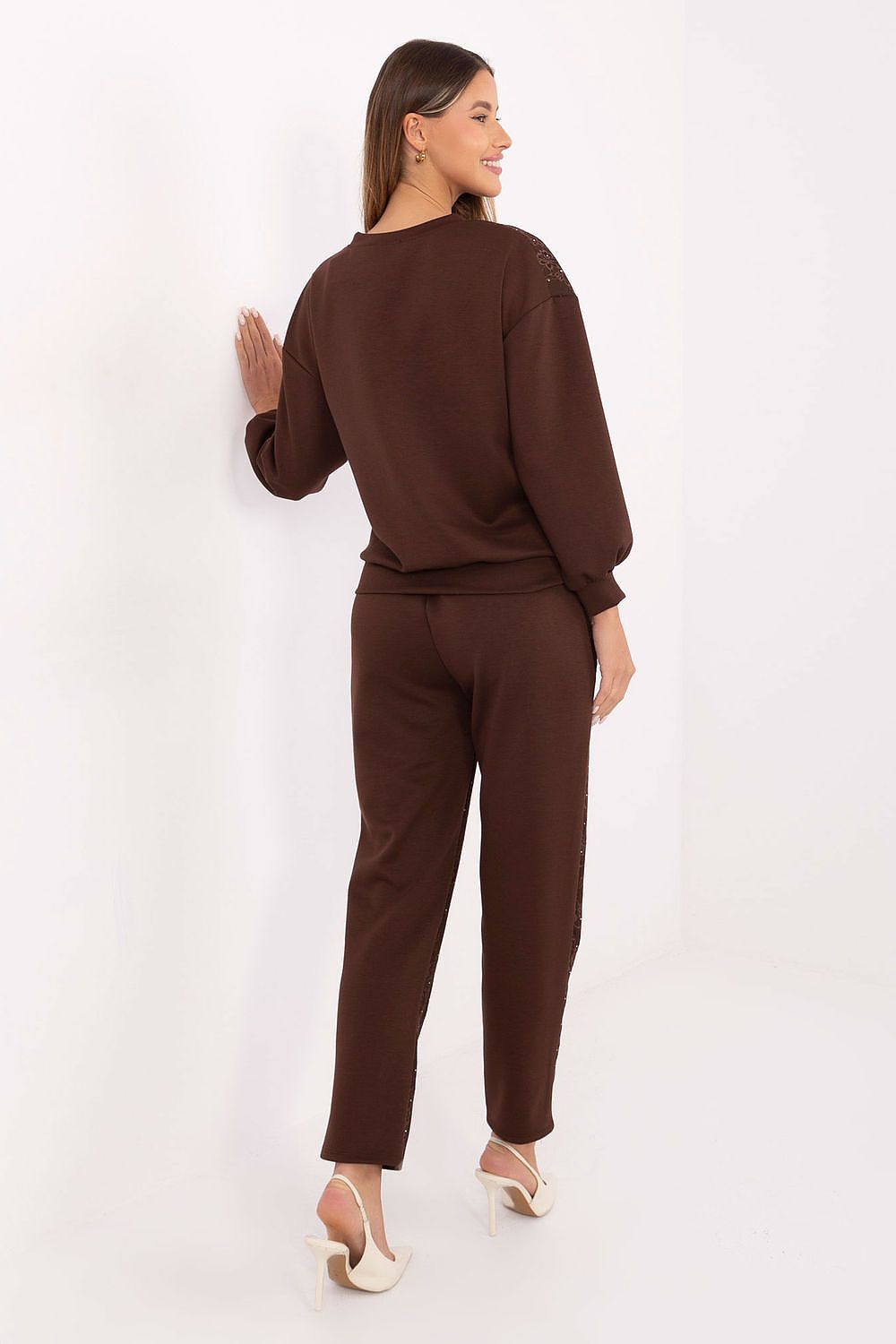 Detailed close-up of brown tracksuit lace and jet applications, rear view