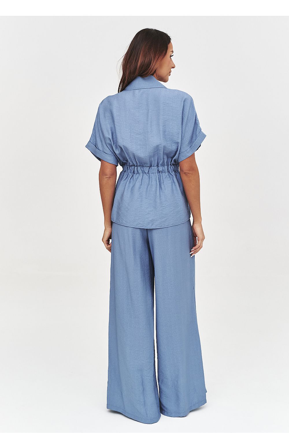 Woman wearing a blue jumpsuit on a white background