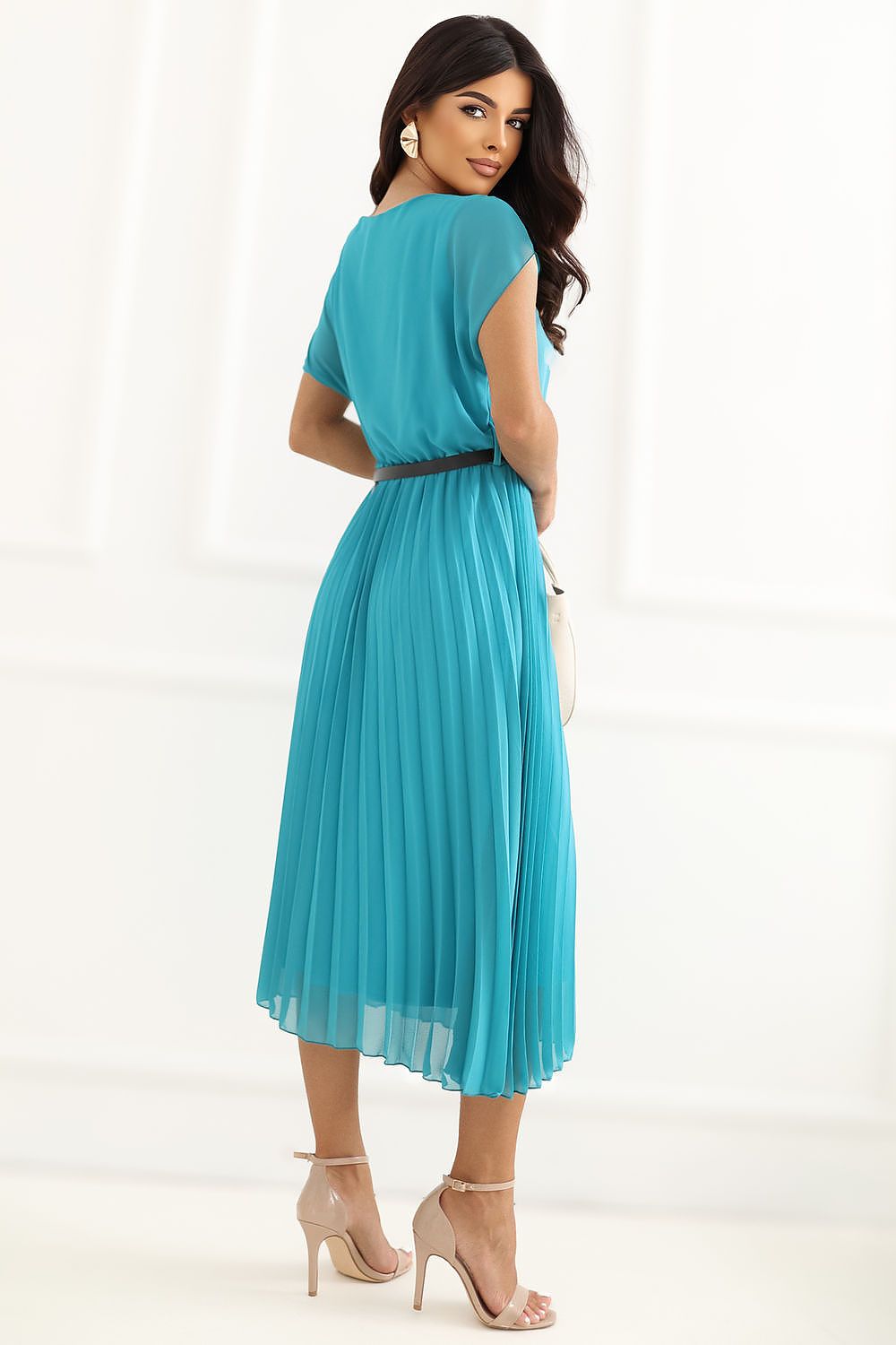 A woman modeling a turquoise blue midi dress with short sleeves, a pleated skirt, and a thin black belt, shown from the back against a white studio background.