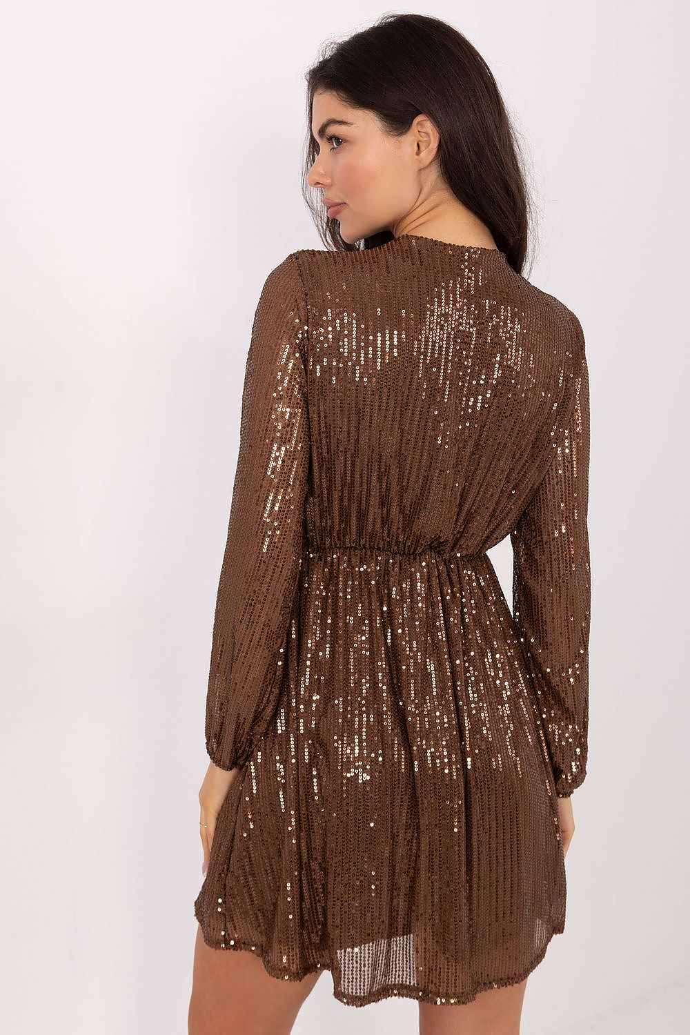 A woman modeling a brown long-sleeve sequined mini dress from the back, showing a pleated texture and shimmering sequins against a plain white background.
