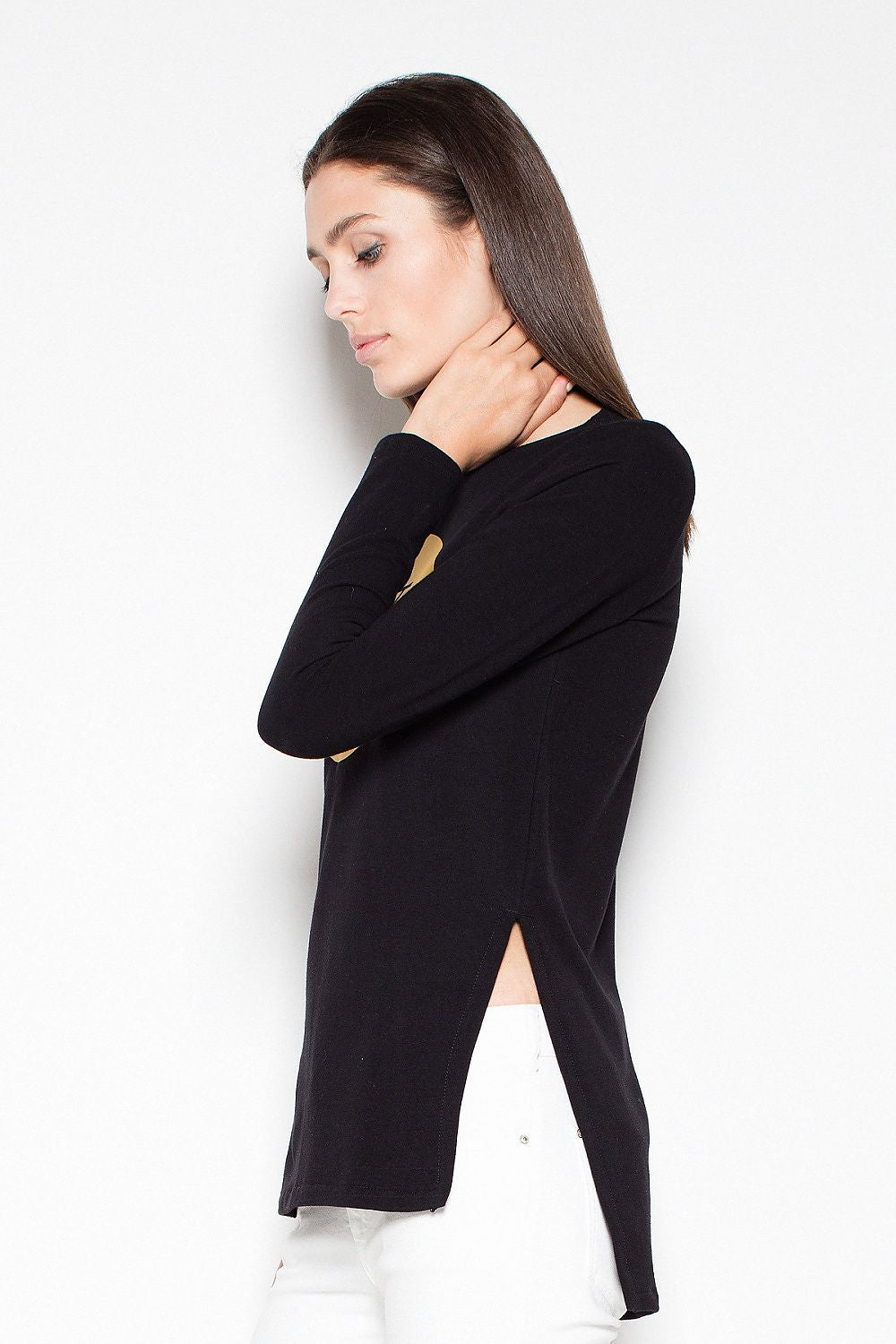 Woman wearing a black long-sleeve top with a high slit on a white background