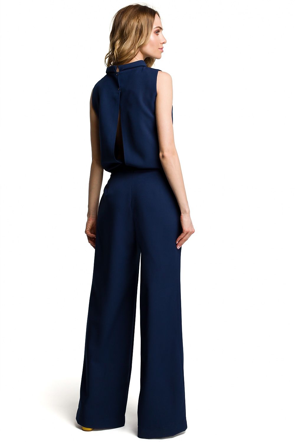 Woman wearing a navy blue jumpsuit on a white background