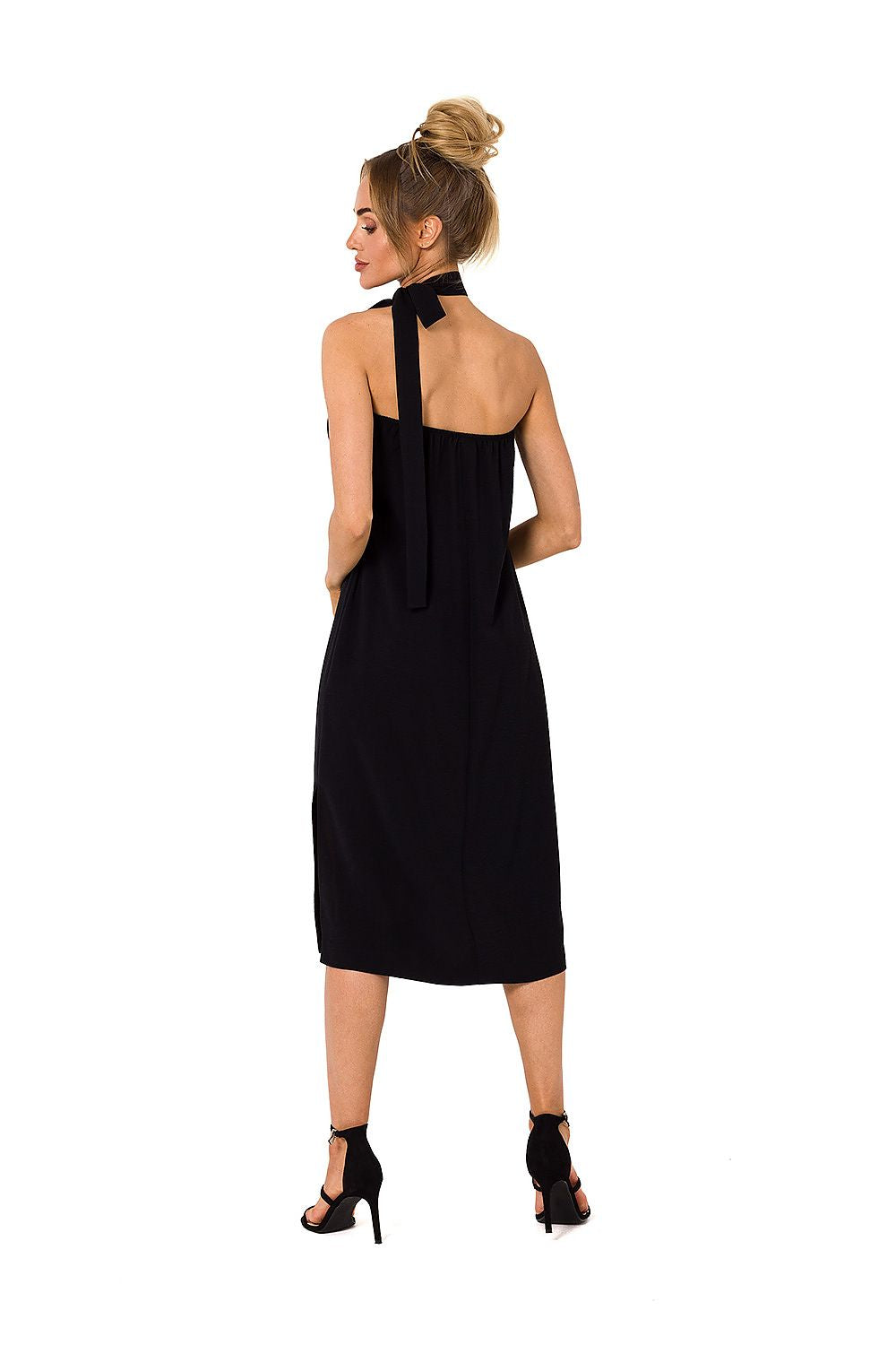 Woman wearing a black dress with a halter neck design on a white background