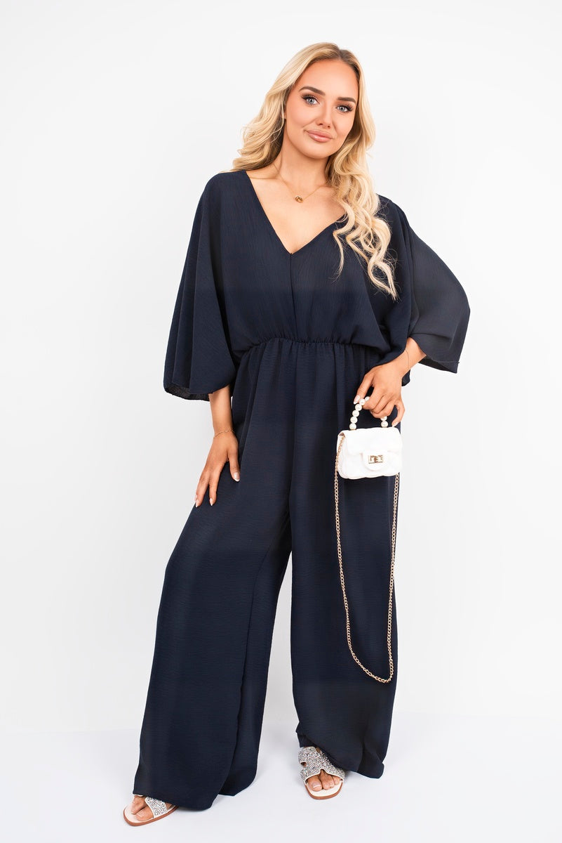 Navy: “Wide leg V-neck jumpsuit in navy with back tie detail, front view”