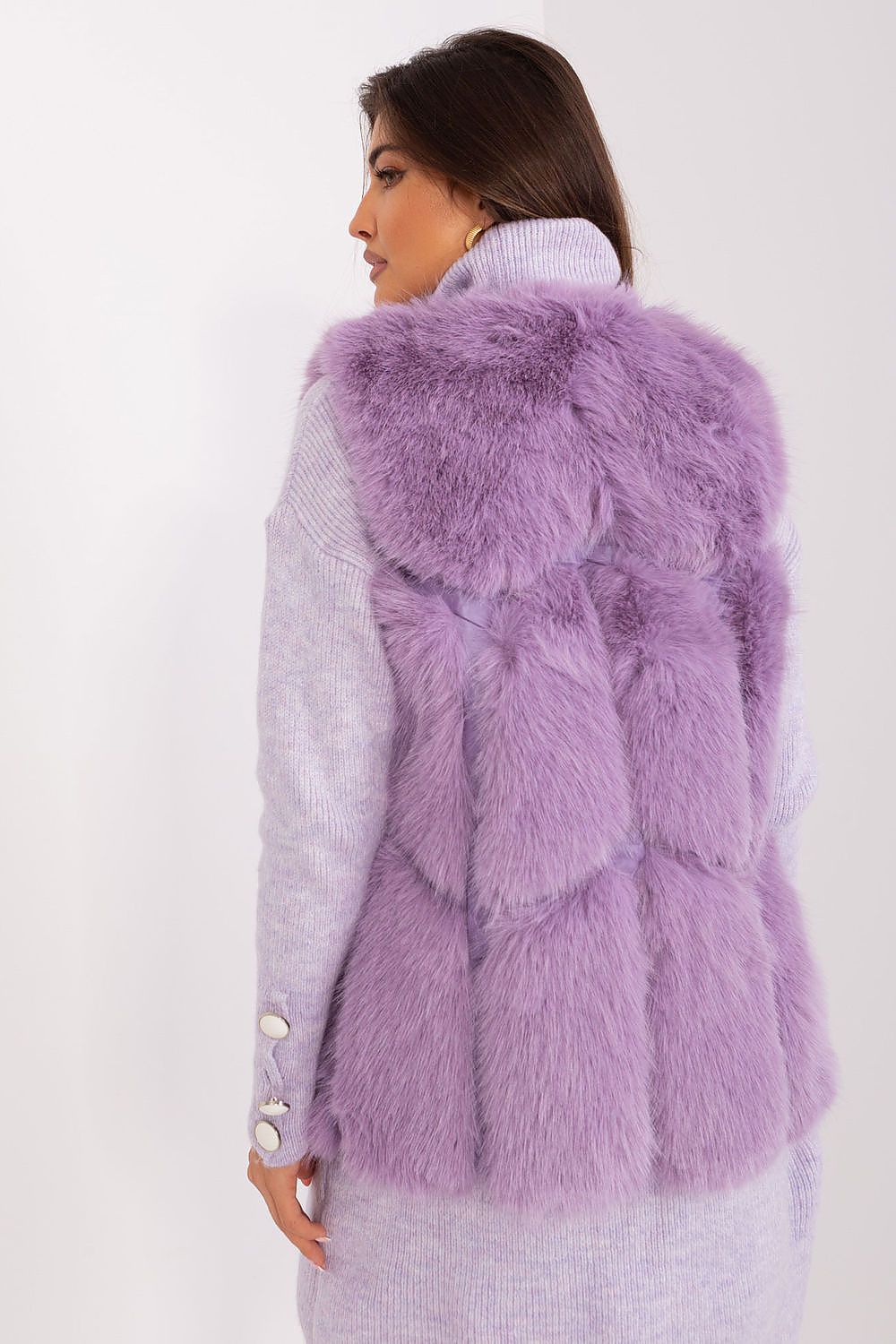 Woman wearing a purple fur vest against a white background