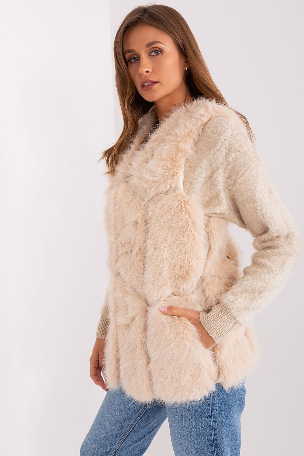 Woman wearing a beige fluffy cardigan on a white background