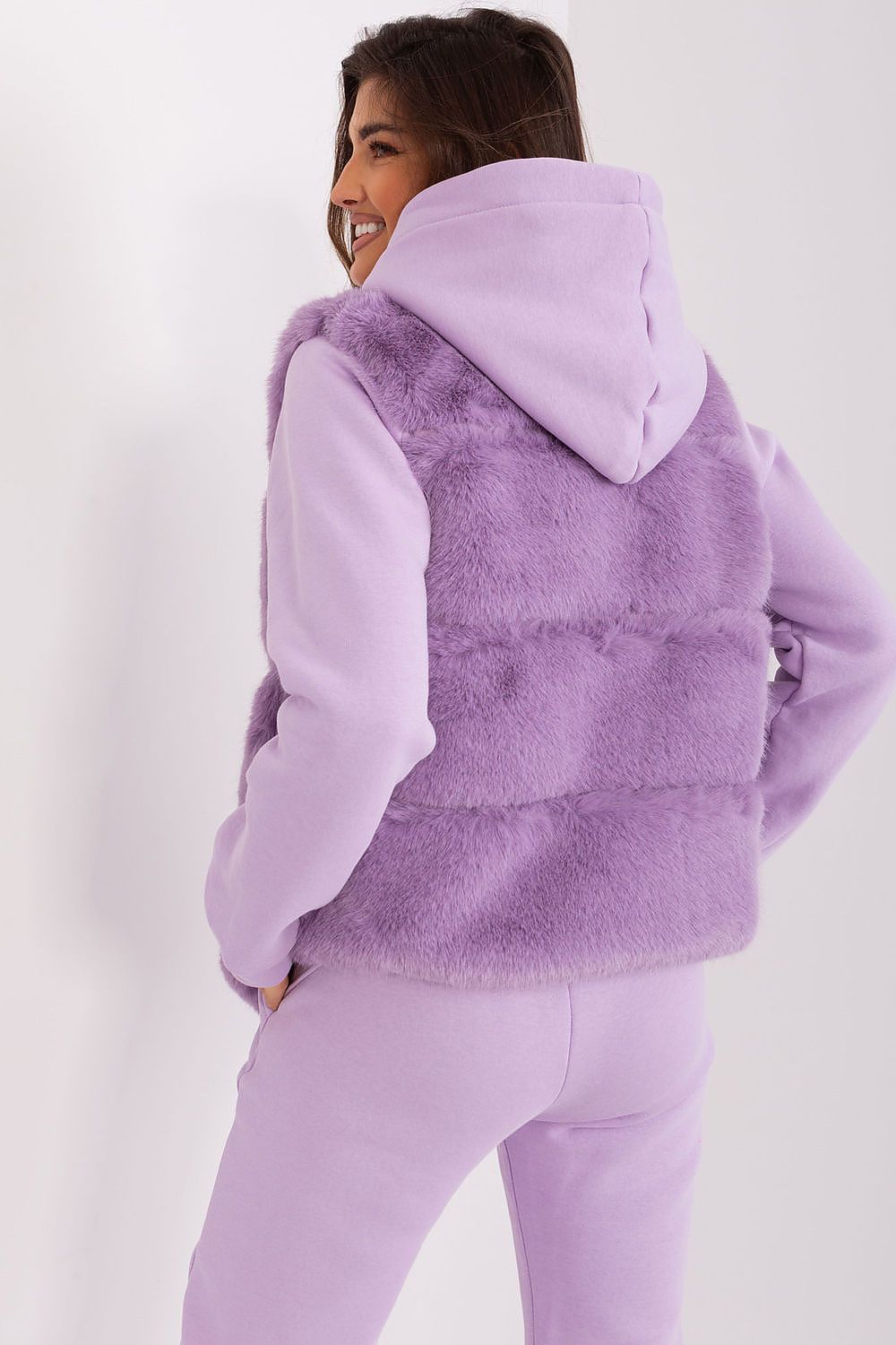 Person wearing a purple fleece vest and pants on a white background
