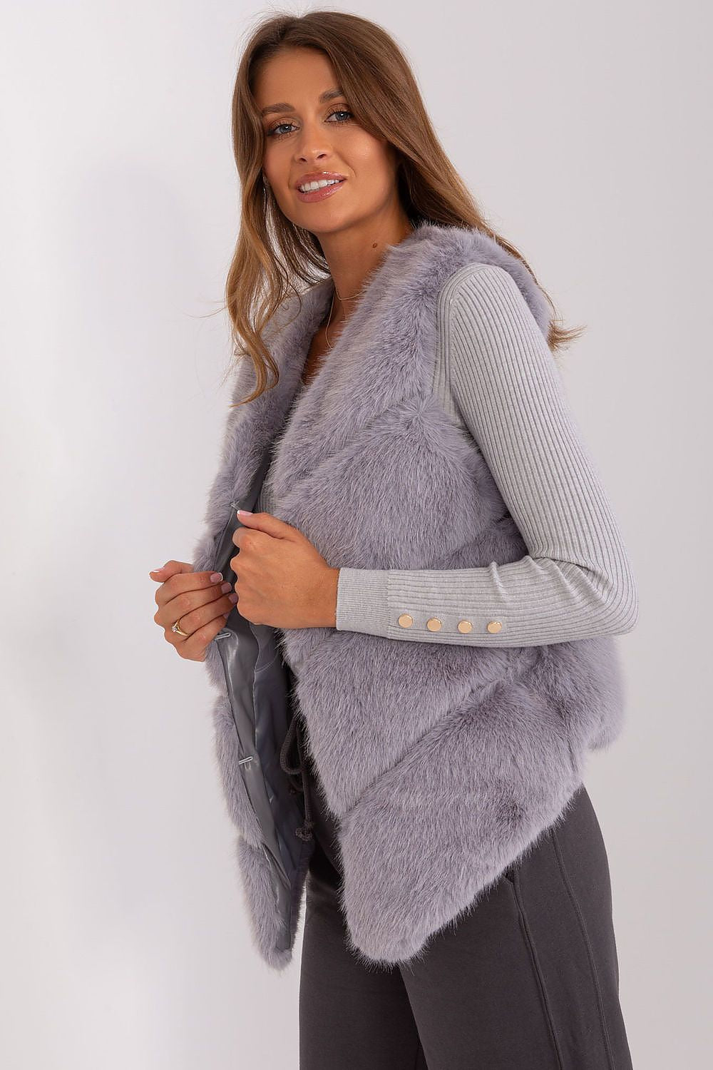 Woman wearing a light purple fur vest over a gray sweater on a white background