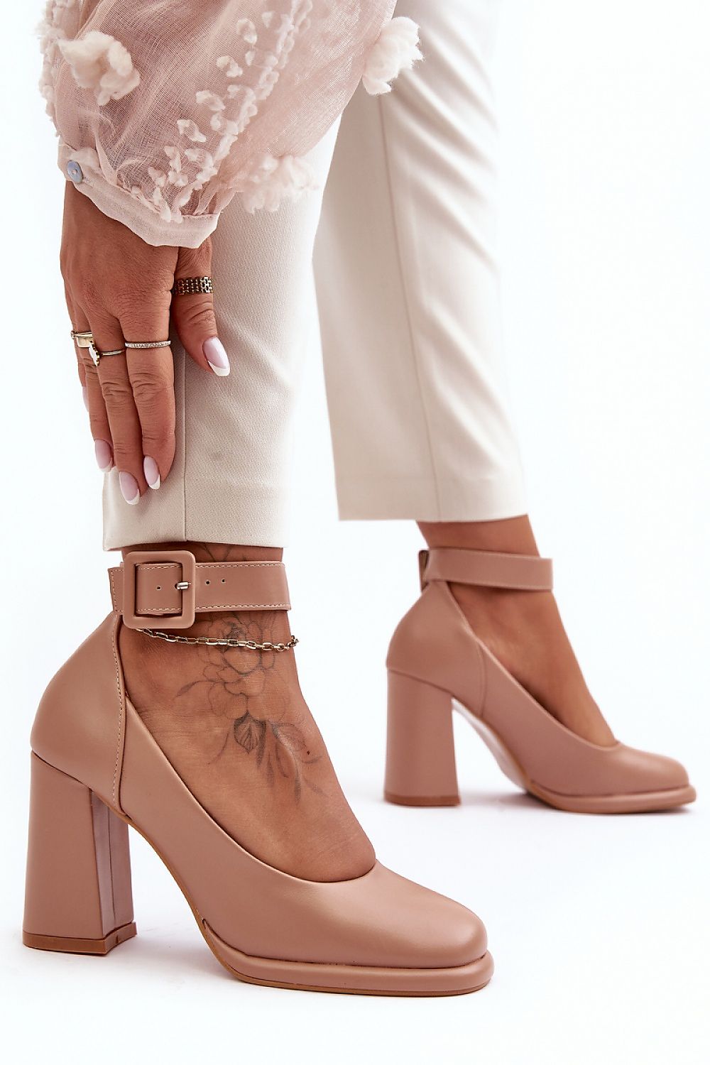 Pair of beige ankle boots with block heels on a white background