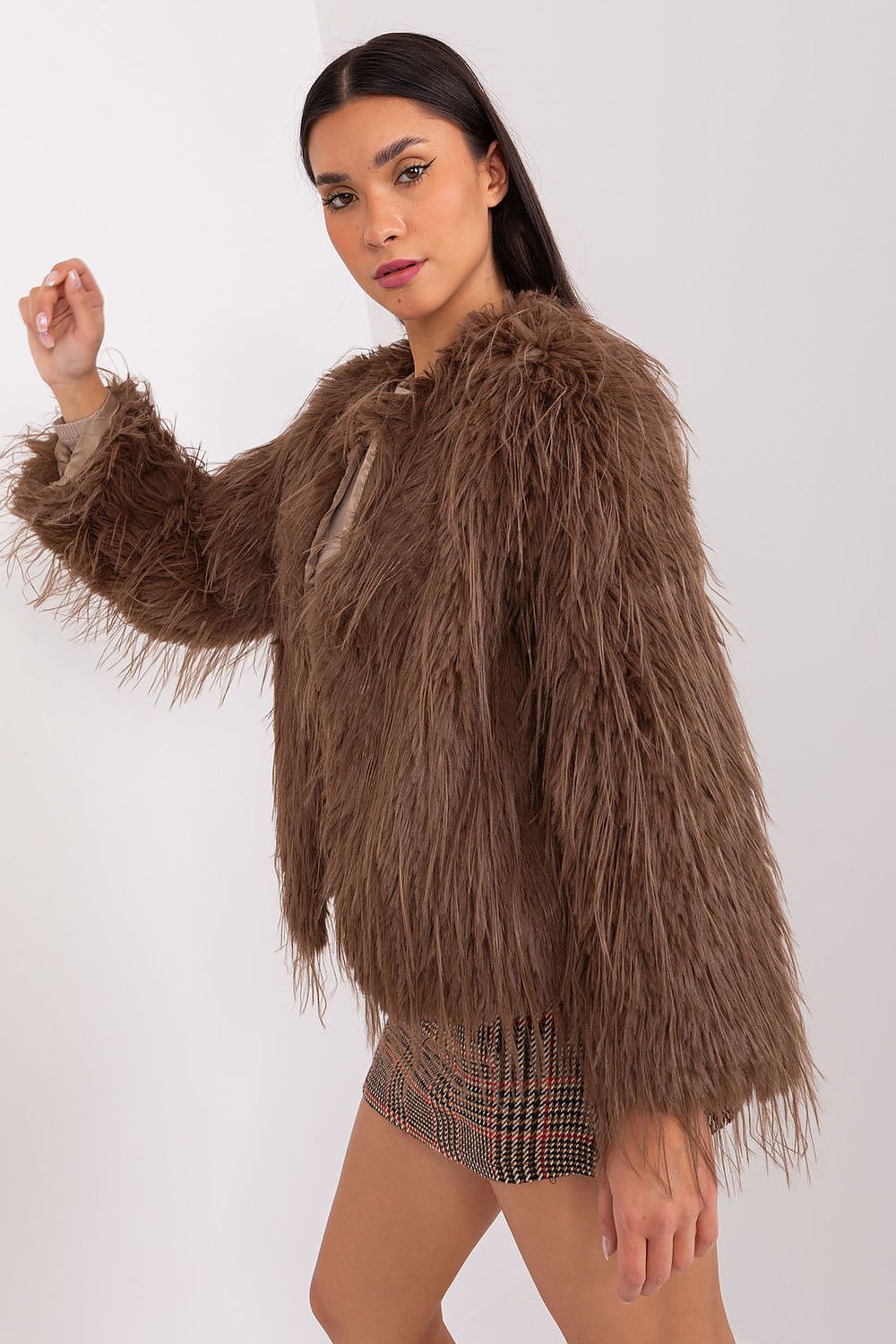 Woman wearing a brown fluffy jacket on a white background