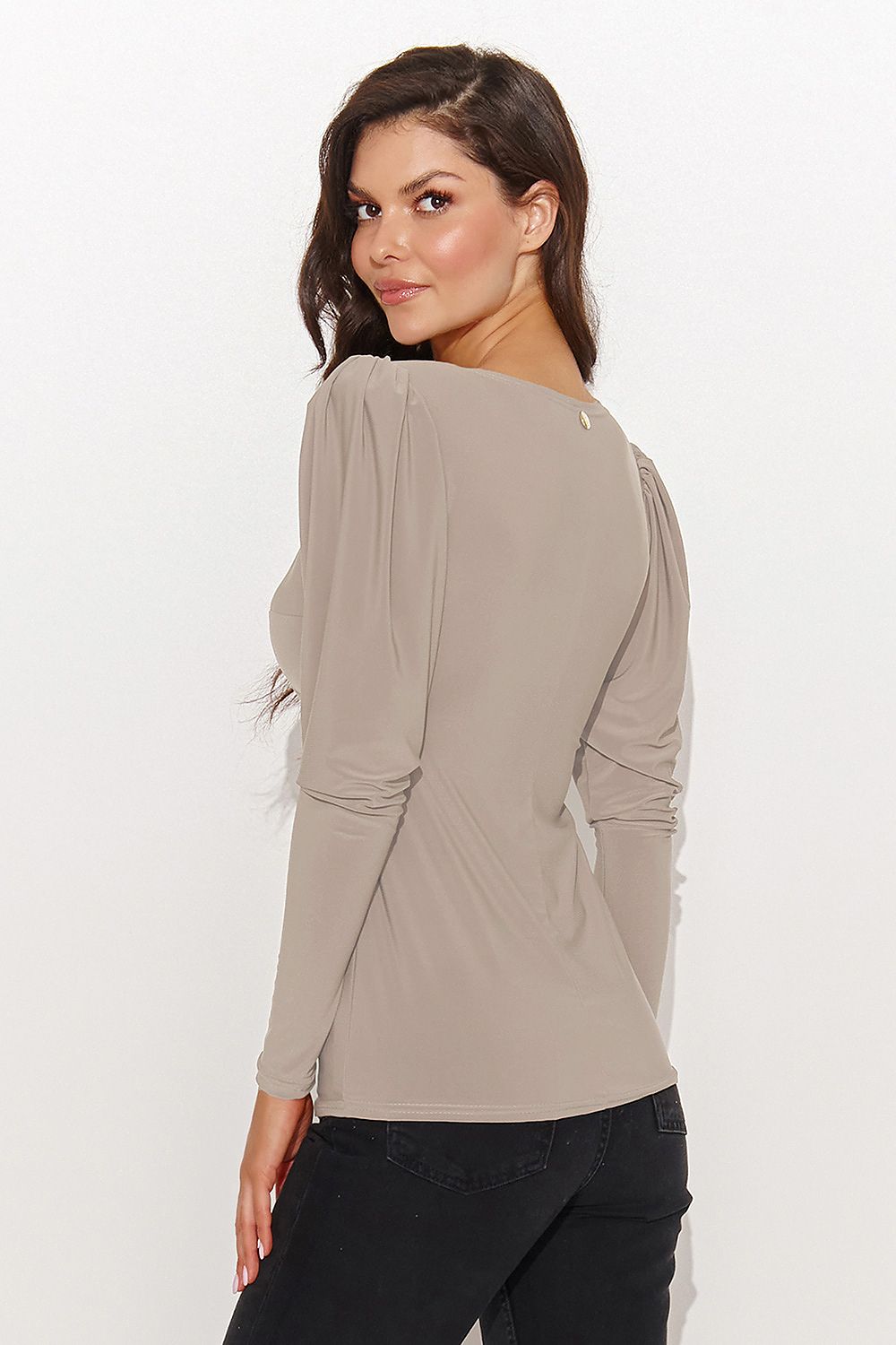 Woman wearing a beige long-sleeve top on a white background