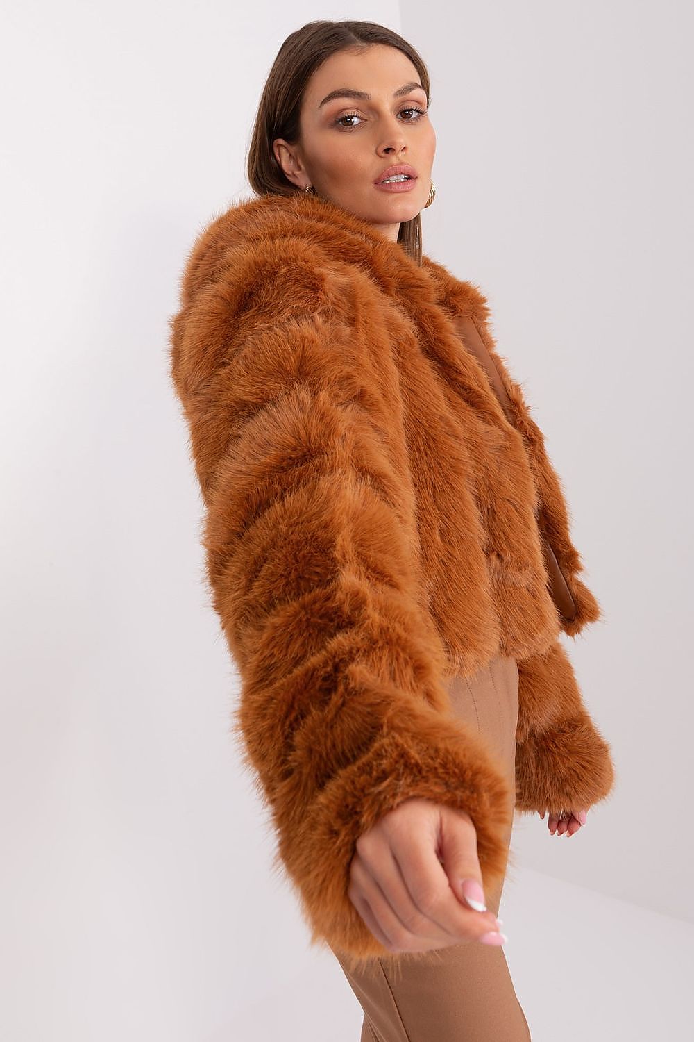Woman wearing a brown fluffy jacket on a white background