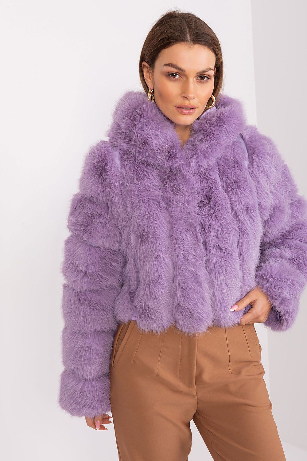 Woman wearing a purple fur coat against a white background