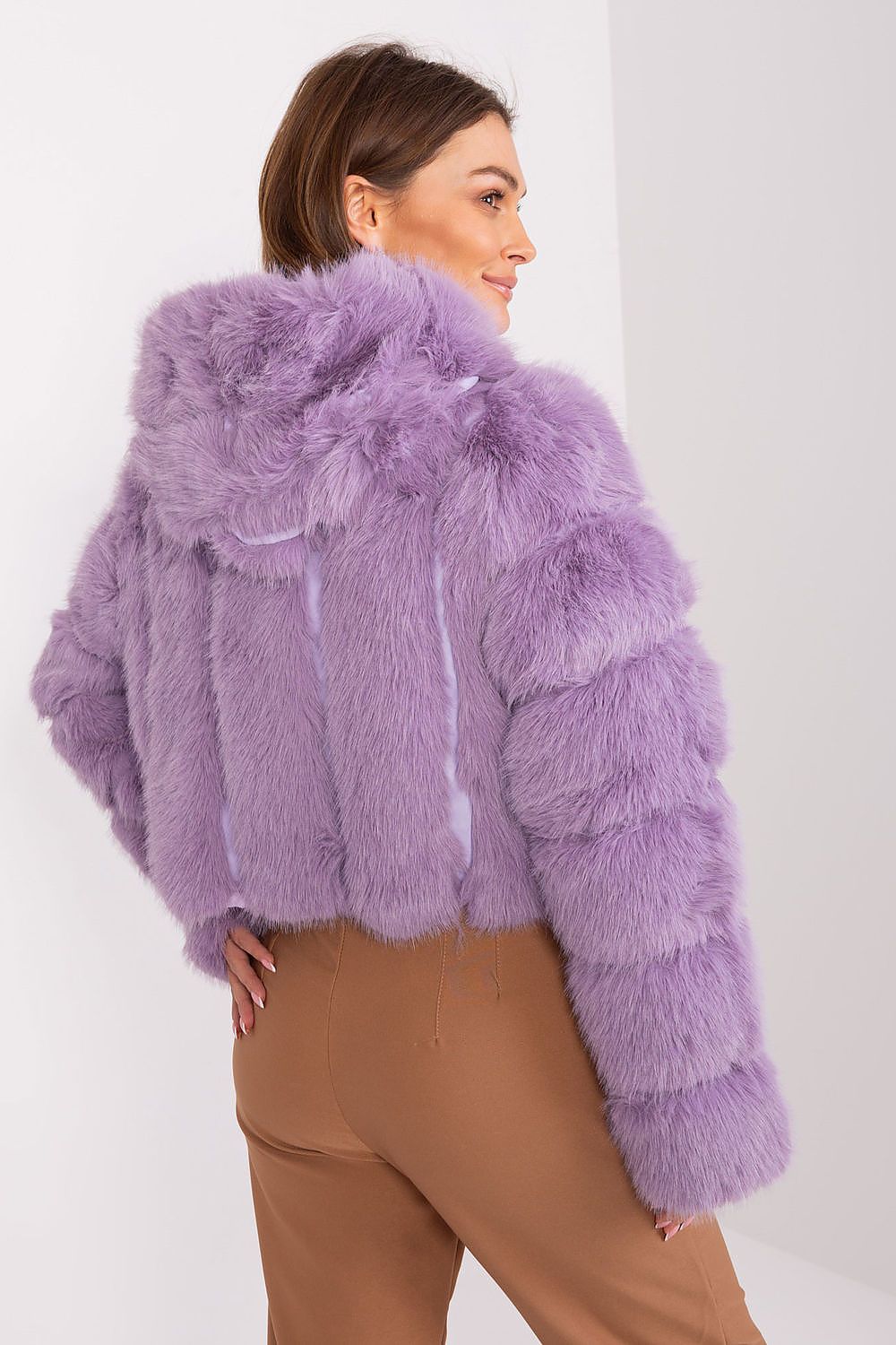 Woman wearing a fluffy purple jacket on a white background