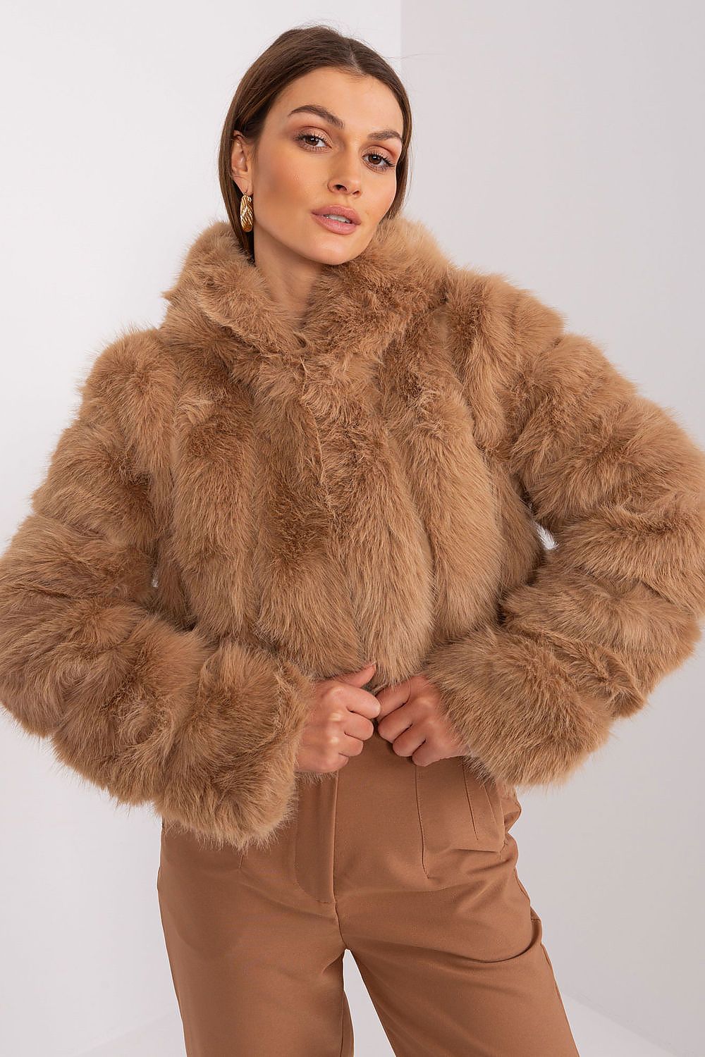Woman wearing a brown fur jacket and pants on a white background