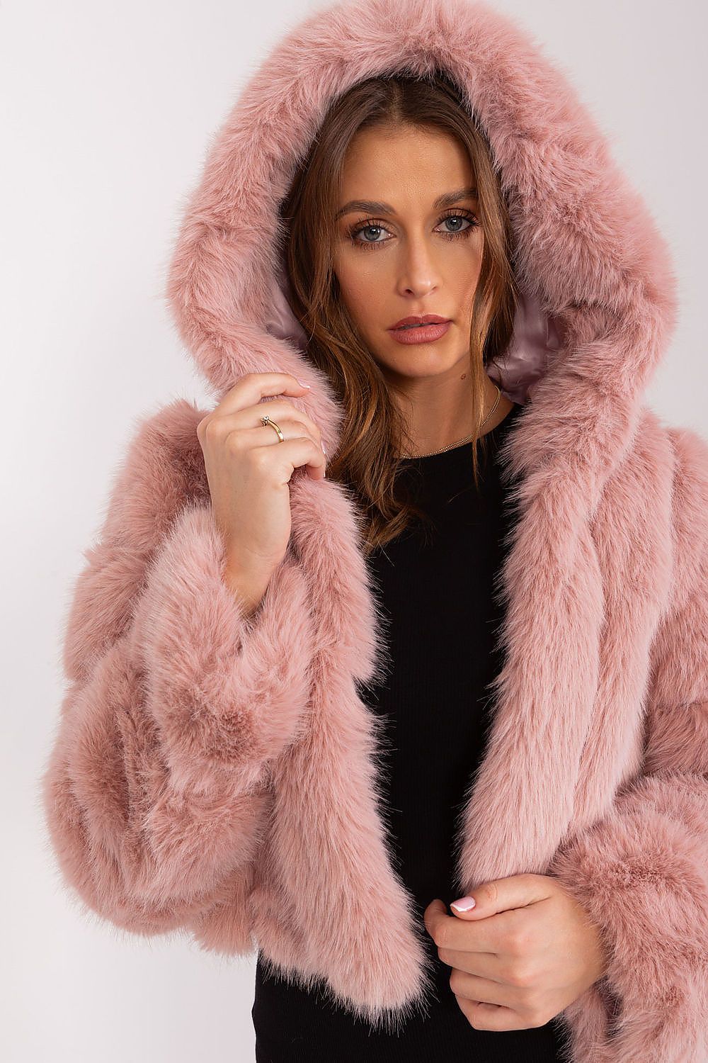 Woman wearing a pink fluffy coat on a white background