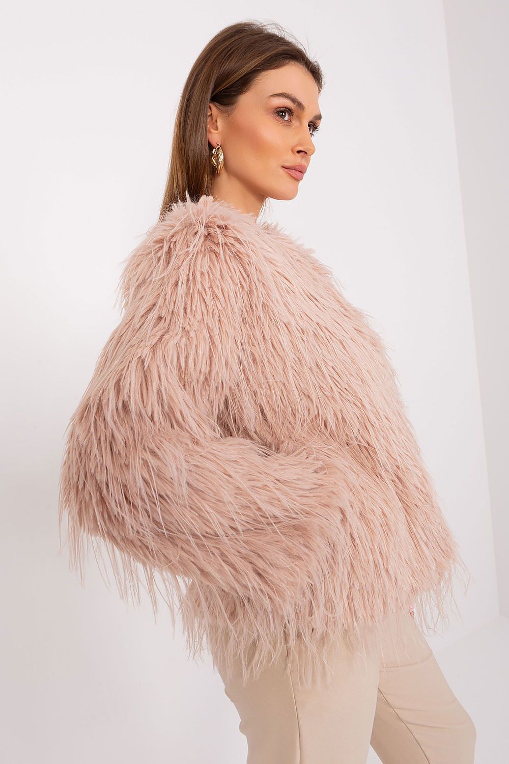 Woman wearing a fluffy pink jacket against a white background