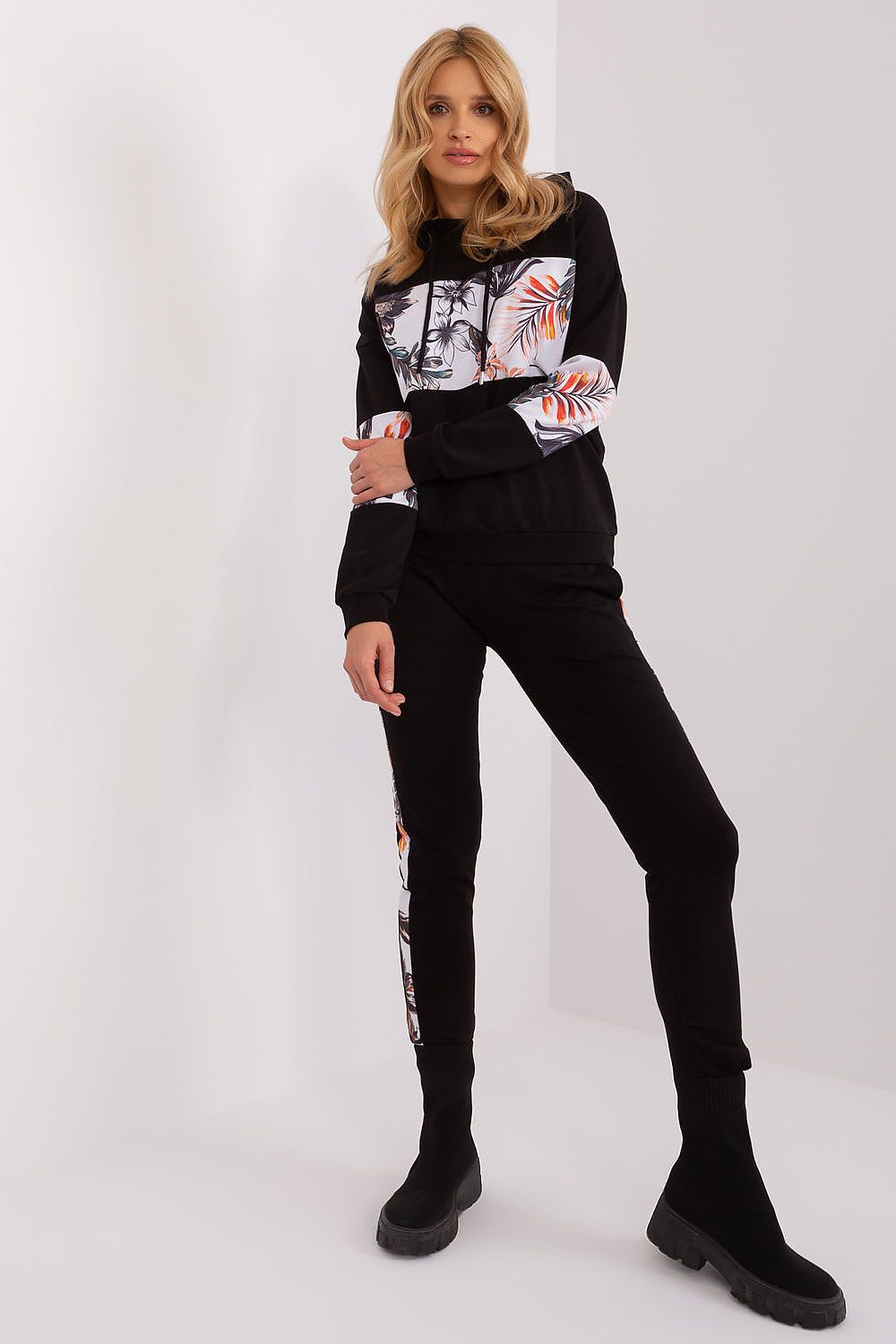 Woman wearing a black outfit with graphic designs on a white background