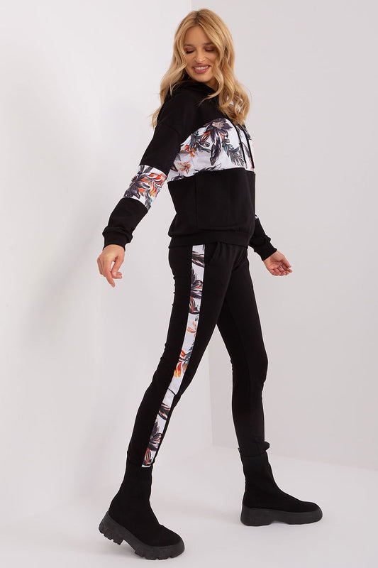 Woman wearing a black and white floral tracksuit on a white background