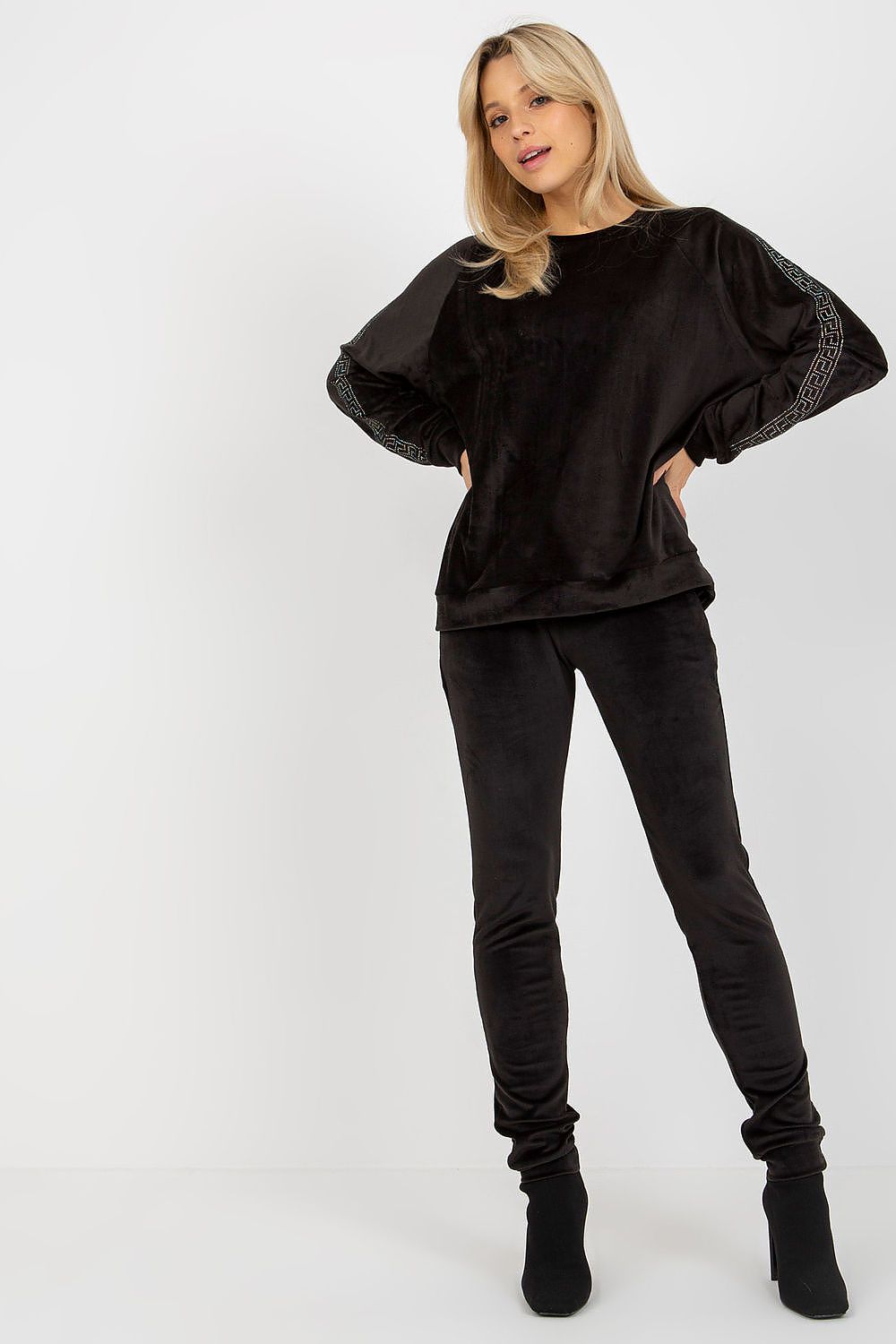 Woman wearing a black outfit with puffed sleeves on a white background