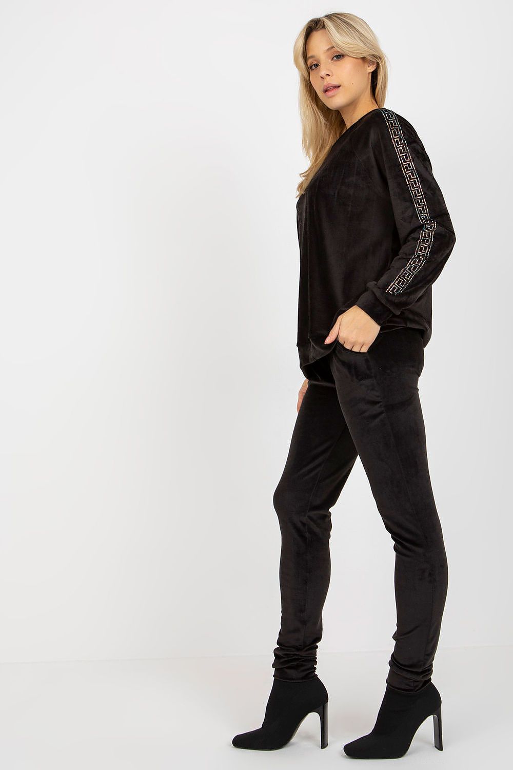 Woman wearing a black outfit with embroidery on a white background