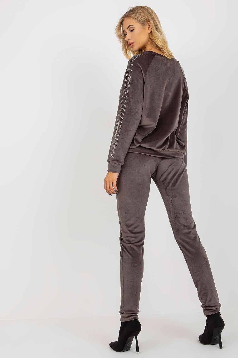 Woman wearing a brown tracksuit on a white background