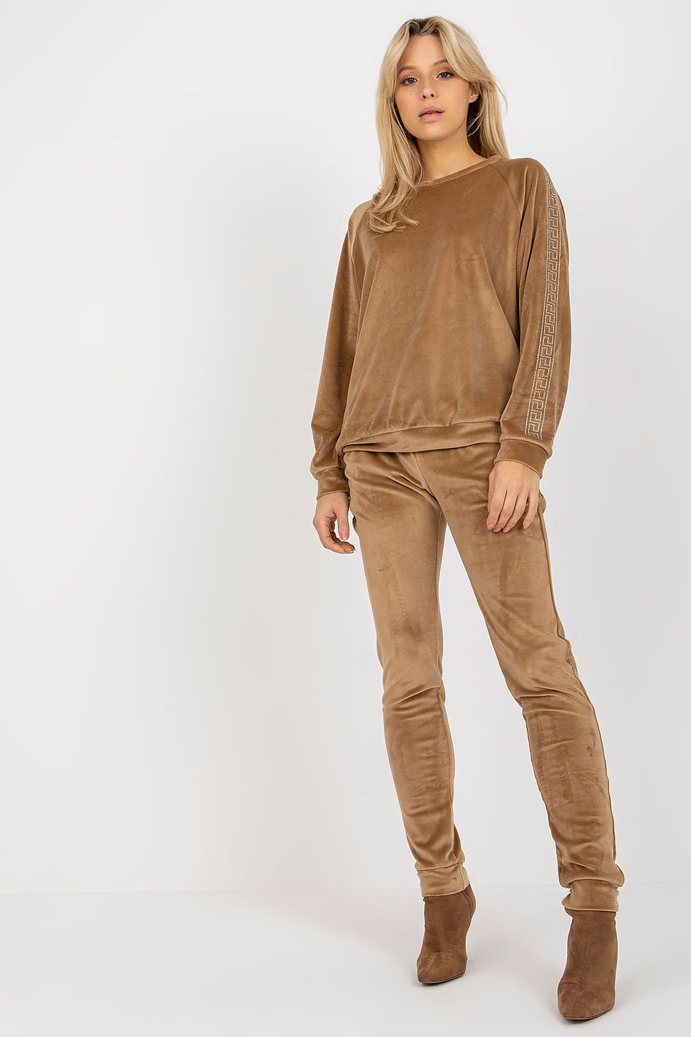 Woman wearing a brown velvet outfit on a white background