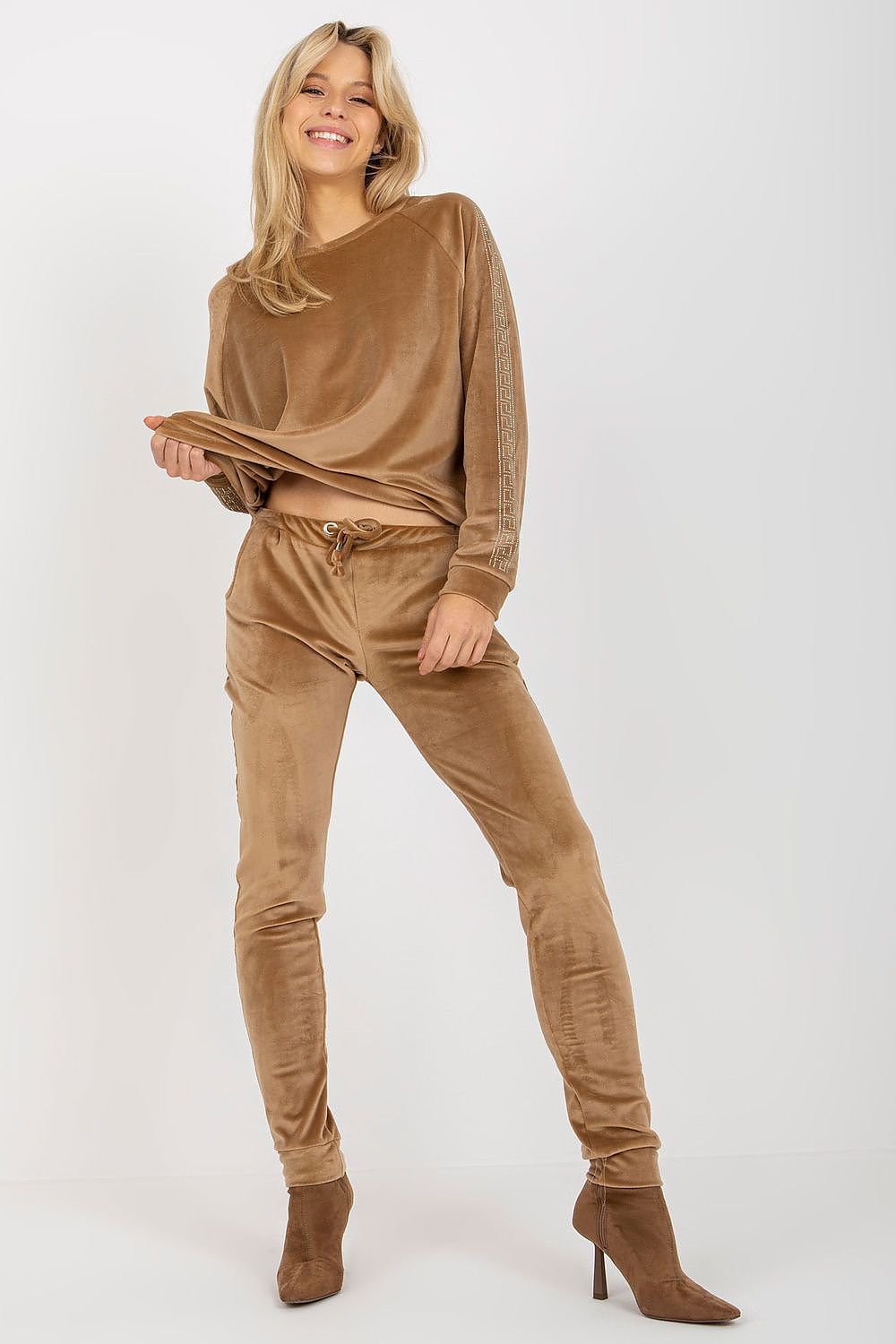 Woman wearing a brown outfit with matching shoes on a white background