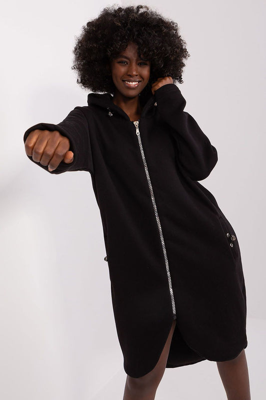 Person wearing a black zip-up hoodie dress on a white background
