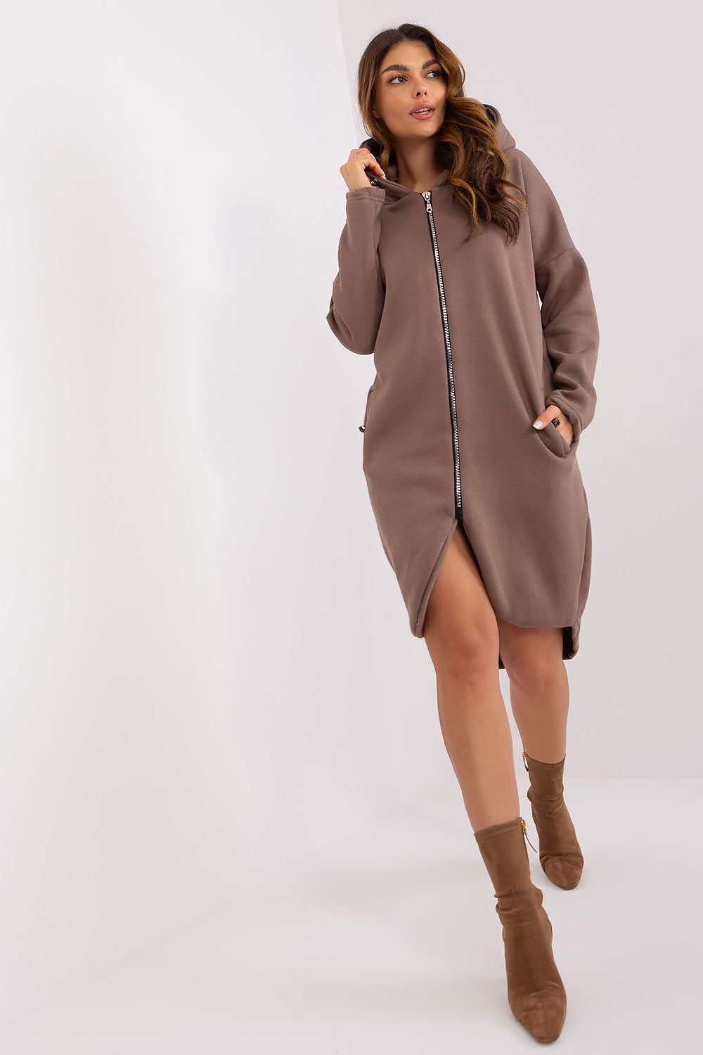 Woman wearing a brown hooded dress with a zipper on a white background
