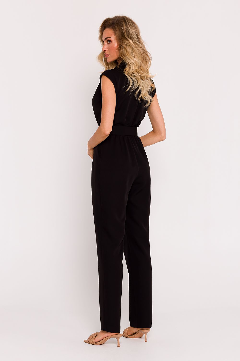 Woman wearing a black jumpsuit on a white background