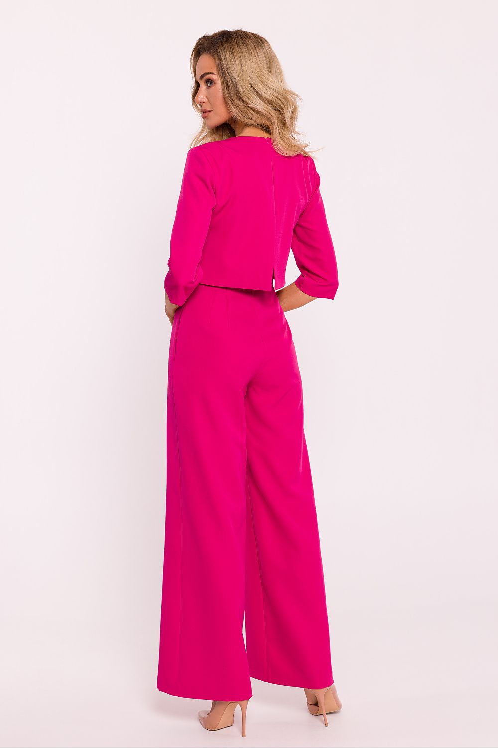 Woman wearing a bright pink outfit on a white background