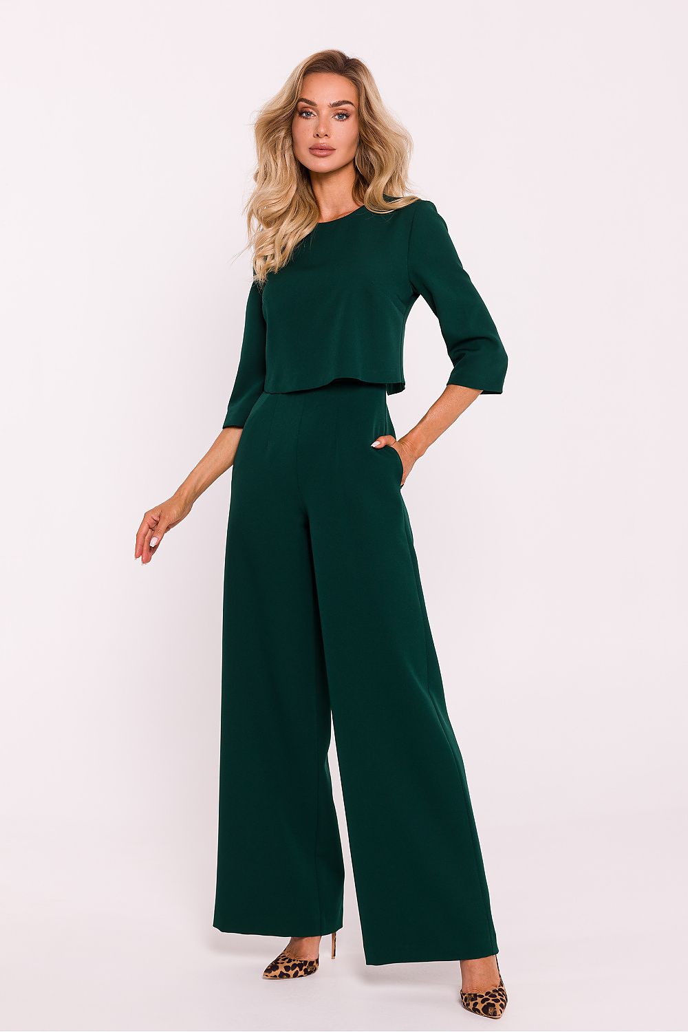 Woman wearing a green jumpsuit on a white background